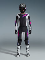 Motocross rider wearing complete racing gear, Alpinestars 2026 Fluid Grid Jersey and matching pants in black and light gray with vibrant purple accents, black helmet with purple goggles, white motocross boots, and black gloves, coordinated outfit for off-road performance
