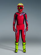 Motocross rider wearing the 2026 Fluid Grid Jersey in Red Black Purple, matching red pants with purple logos, red helmet with neon yellow accents, neon yellow boots, full coordinated racing kit for off-road motocross