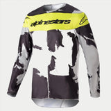 Alpinestars 2023 Racer Tactical Jersey, motocross shirt, Cast Gray Camo en Yellow Fluo, voorzien van een grijs en zwart camouflagepatroon met een felgeel borstpaneel en Alpinestars-logo, duurzame performance-kleding met lange mouwen voor off-road racing