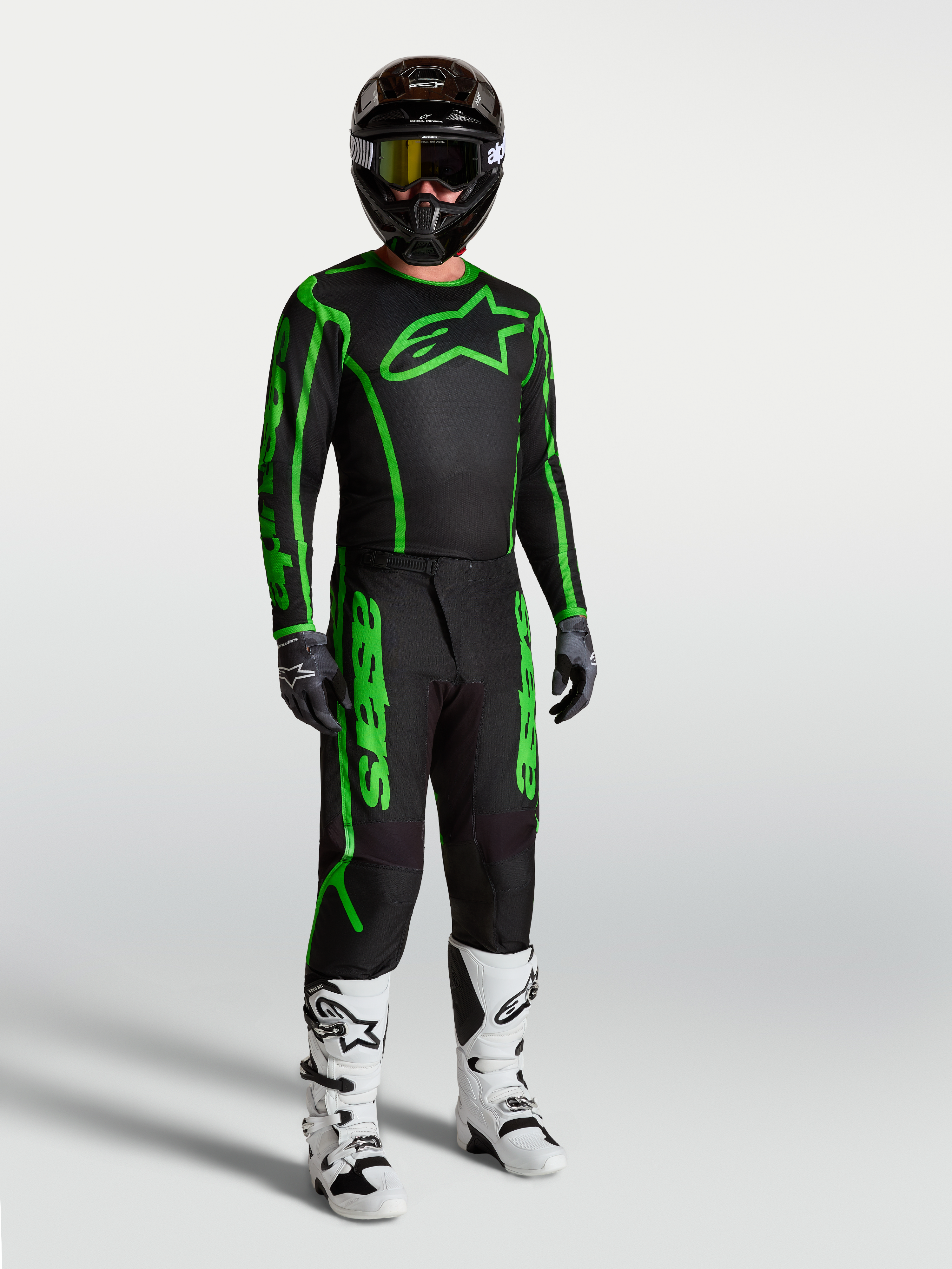 Alpinestars Fluid Apex V2 Jersey, Men's Motocross Gear, Black and Green Fluo, shown on-model with matching pants and boots.