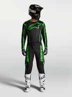 Alpinestars Fluid Apex V2 broek, heren motocrossuitrusting in zwart en fluogroen, volledige race-outfit met witte motorlaarzen en zwarte helm.