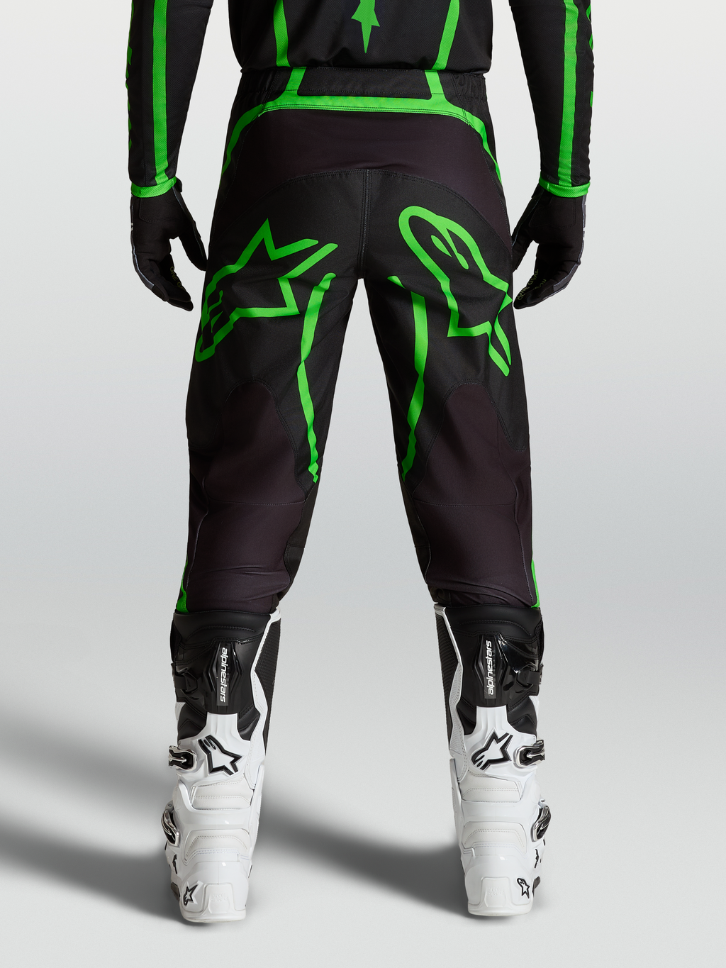 Alpinestars Fluid Apex V2 Broek, motocrossbroek voor heren, zwart en neon groen, achteraanzicht op model met stergrafieken.