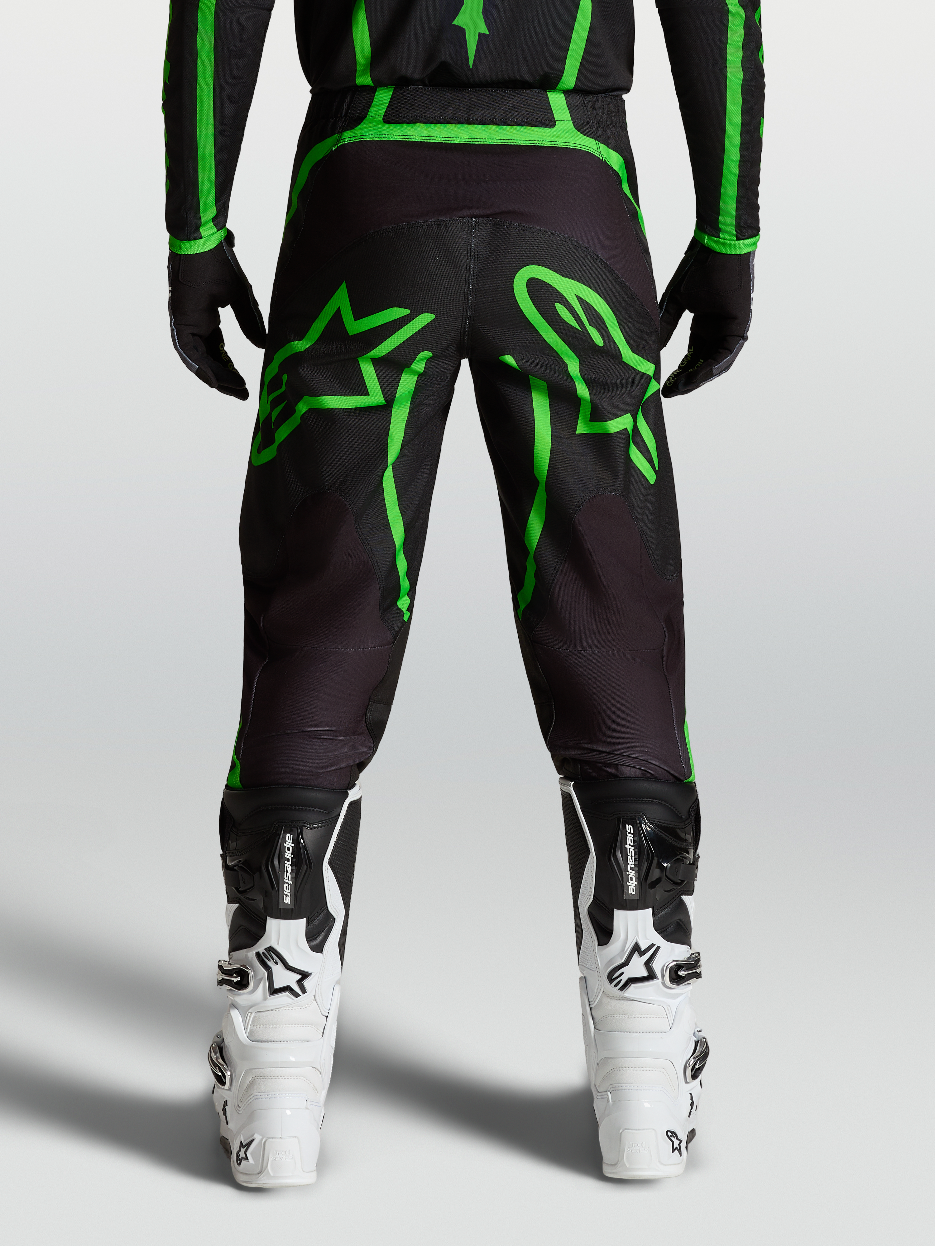 Alpinestars Fluid Apex V2 Broek, motocrossbroek voor heren, zwart en neon groen, achteraanzicht op model met stergrafieken.