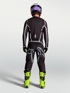 Alpinestars Fluid Apex V2 jersey, heren-motorcrosskleding, zwart en zilver, achteraanzicht op rijder in race-uitrusting.