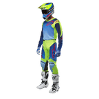 Alpinestars 2024 Racer Hoen Jersey, motocross shirt, geel fluo en blauw night navy, gedragen door een rijder met bijpassende broek, helm en witte laarzen, professionele race-uitrusting voor off-road rijden