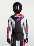 Alpinestars Fluid Drag jersey, heren-motorcrossjersey voor off-road en motocross, zwart en wit met fluo rode accenten en agressieve graphics, vooraanzicht gedragen door een model met helm.