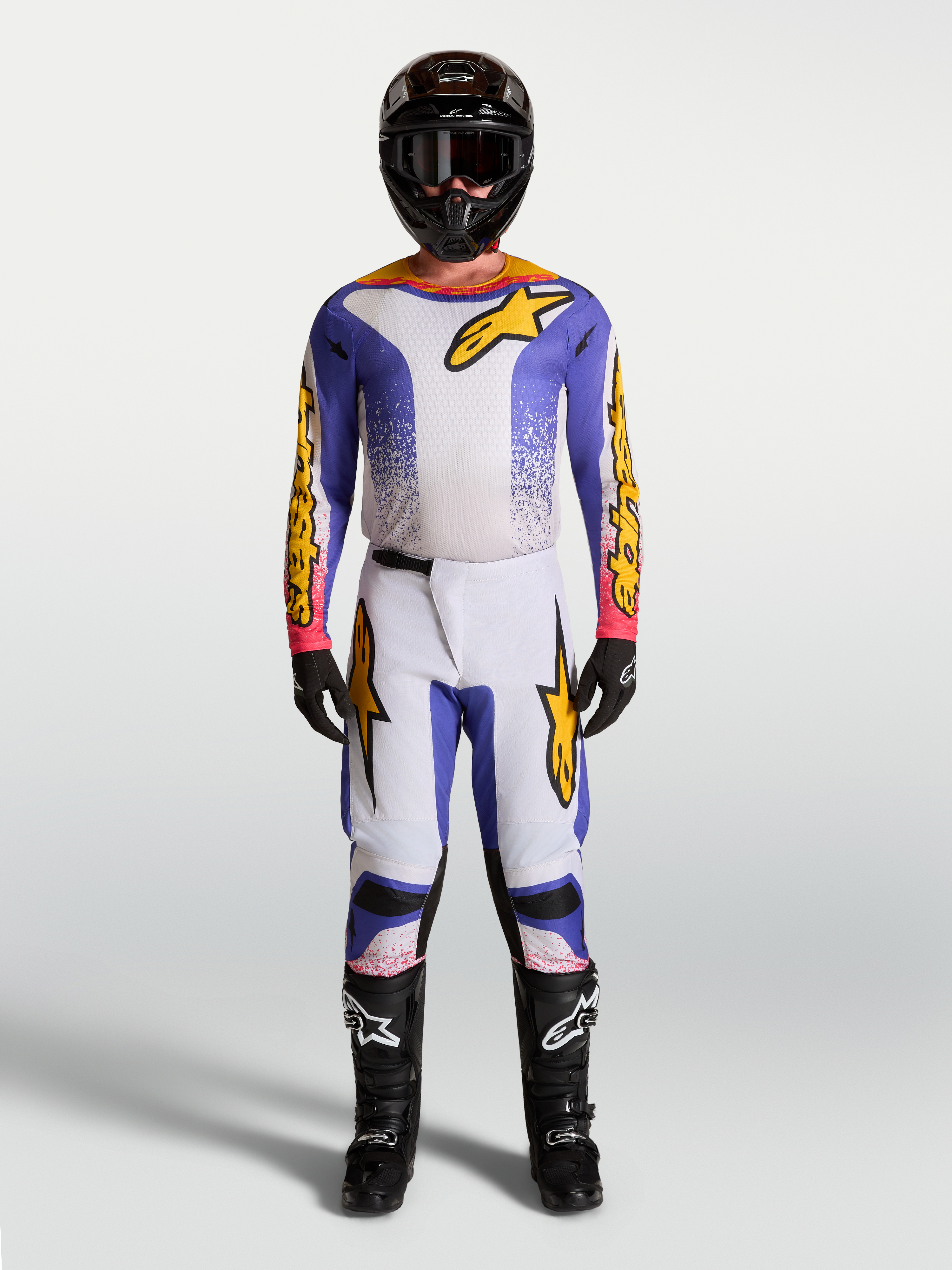 Alpinestars Fluid Drag motocrossset voor heren, lila, blauw en goud, met jersey en broek voor professionele off-road prestaties.