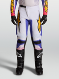 Alpinestars Fluid Drag heren motocrossbroek 2027 in licht lila en iris blauw met gouden accenten.