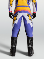 Alpinestars Fluid Drag broek, motorcrossbroek voor heren, blauw en goud, met stretch corduroy en zwarte motorlaarzen.