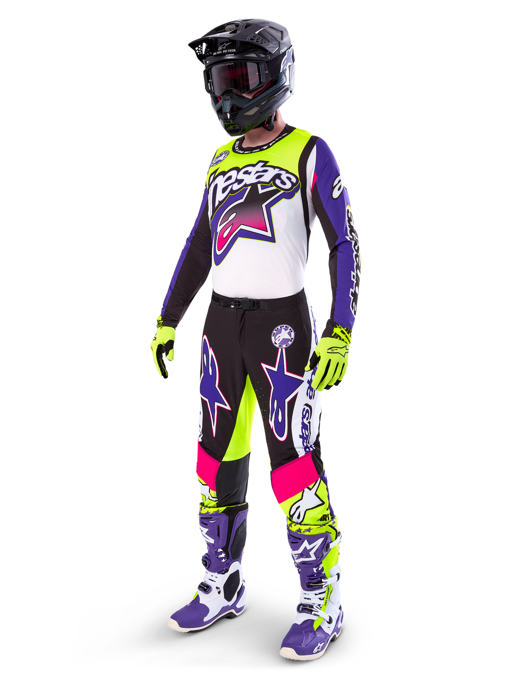 Alpinestars motorcrossrijder in Limited Edition Supertech Dirt Studios® uitrusting, kleurenschema in wit, paars en fluogeel, zwarte broek met opvallende paarse en roze sterlogo's, fluogele handschoenen, paars-witte racelaarzen, zwarte helm, complete professionele racekit voor off-road prestaties