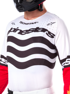 Alpinestars Limited Edition Techstar Deep Jersey, wit motorcross shirt met golvende zwarte horizontale strepen en rode mouwen, voorzien van Alpinestars- en Techstar-branding, kleine lasergesneden perforaties op de bovenborst voor ventilatie, sportieve off-road uitrusting