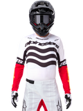 Motorcrossrijder in volledige race-uitrusting, Limited Edition Techstar Deep Jersey in wit en zwart met rode mouwen, voorzien van golvende graphics en opvallende Alpinestars-branding, witte motorcrossbroek, zwarte helm en motorcrossbril, gecoördineerde outfit voor off-road racing.
