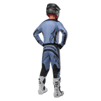 Alpinestars 2024 Fluid Lurv Jersey en bijpassende broek in lichtblauw en zwart, motorcrosser van achteren gezien, met zwarte logo's op de rug en mouwen, gecombineerd met een zwarte helm en witte laarzen