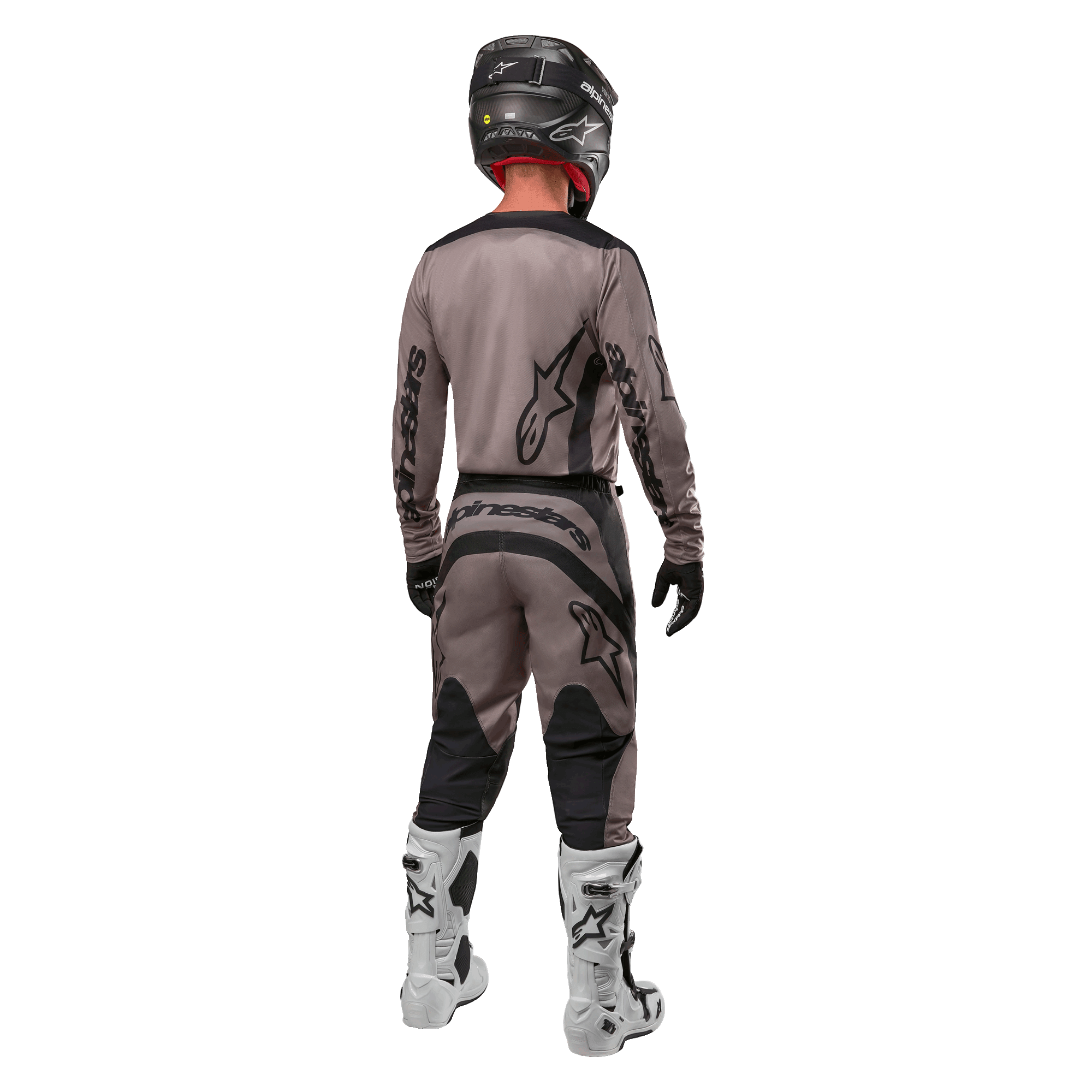 Alpinestars 2024 Fluid Lurv Jersey, motocross jersey, Mud Black, achteraanzicht van een motorcrossrijder in bijpassende race-uitrusting, zwarte helm en witte laarzen, met opvallende zwarte Alpinestars-logo's en een sportieve pasvorm voor off-road prestaties.