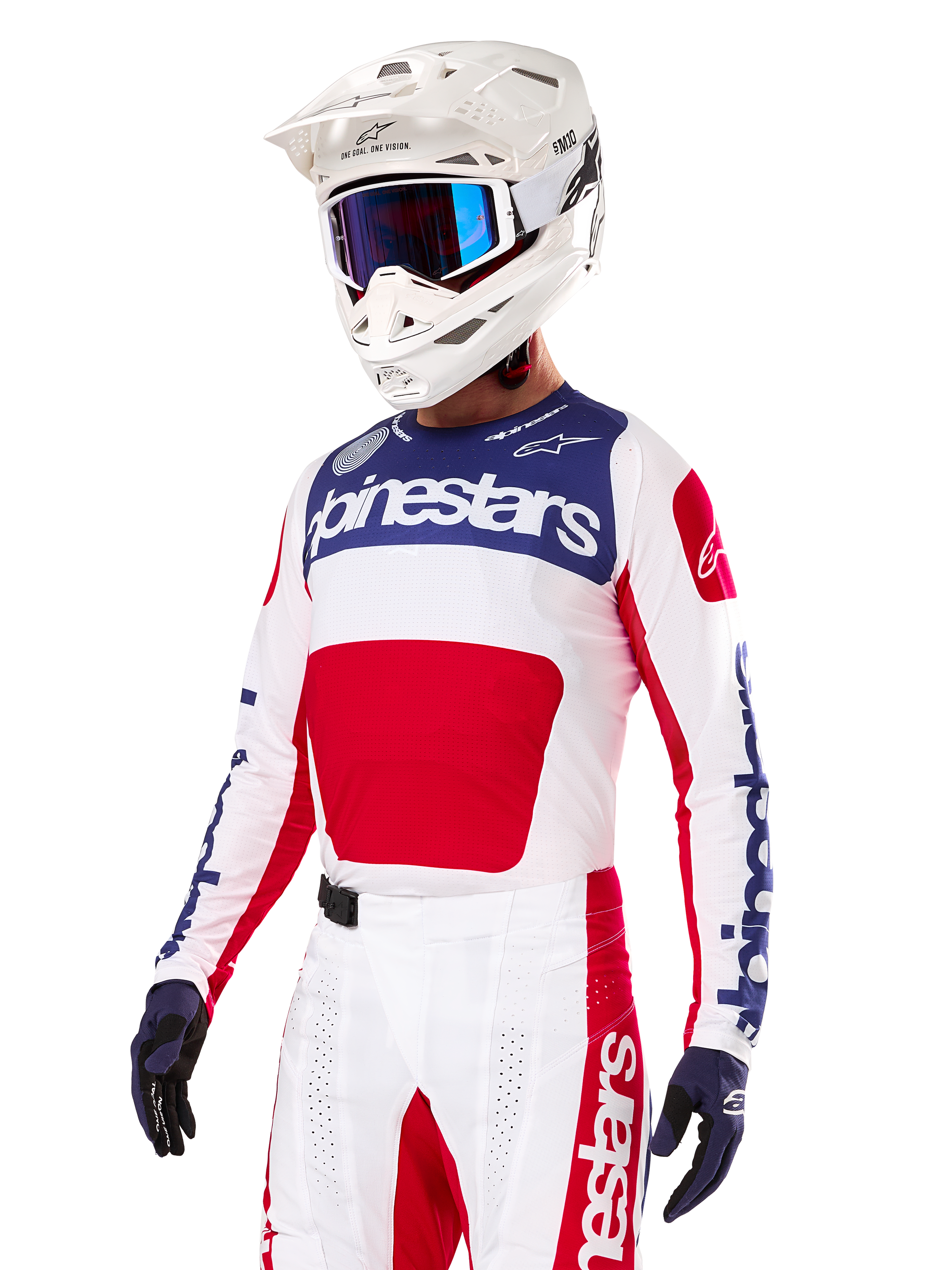 Motocross rider wearing the Alpinestars Limited Edition Techstar Fortitude Jersey, Bright Red White and Blue, featuring a white helmet with blue goggles and matching pants, high-performance racing apparel for off-road competition