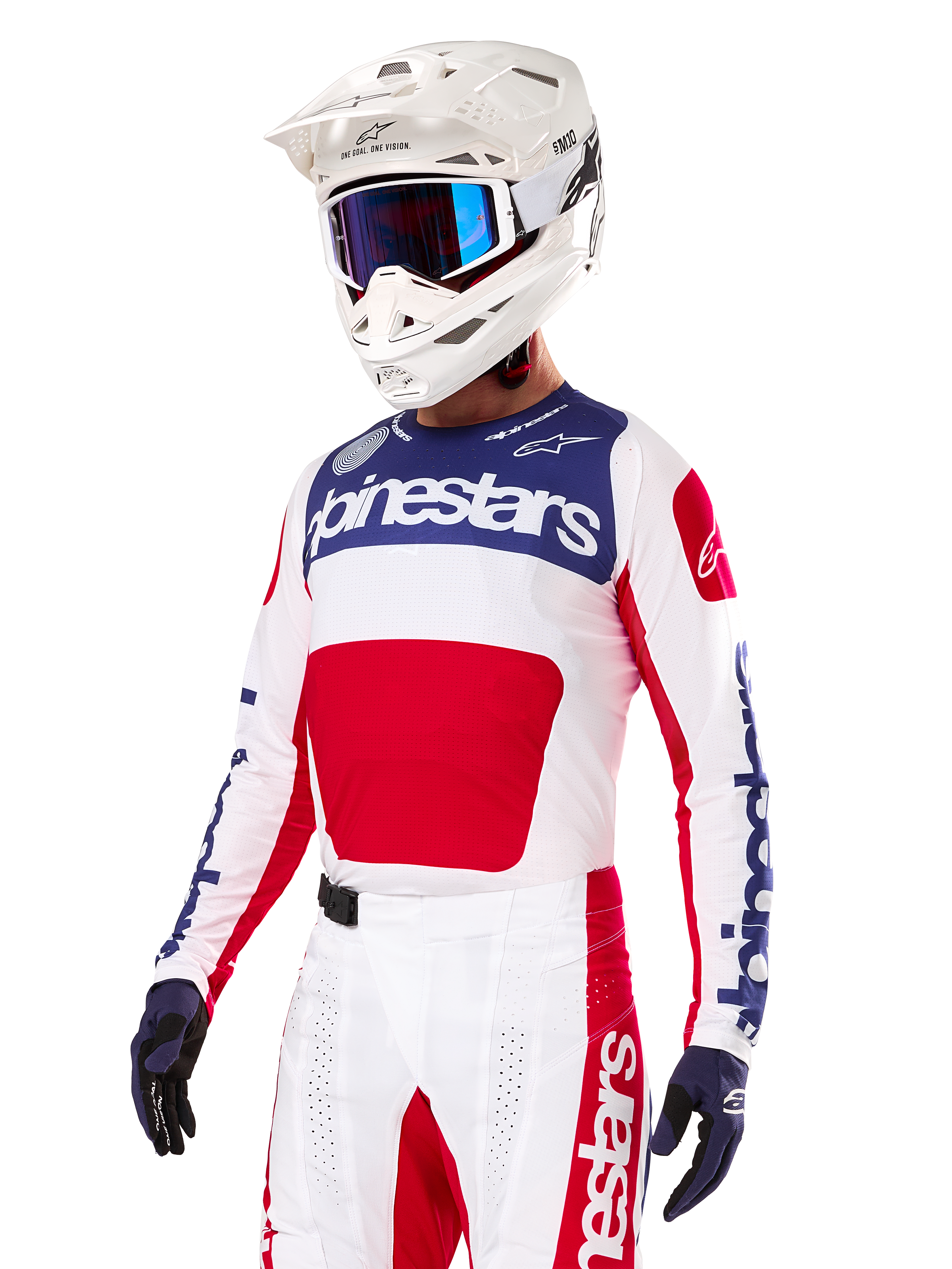 Motorcrosser die de Alpinestars Limited Edition Techstar Fortitude Jersey draagt, in felrood, wit en blauw, met een witte helm, blauwe crossbril en bijpassende broek, hoogwaardige racekleding voor off-road competitie
