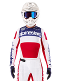 Alpinestars Limited Edition Techstar Fortitude Jersey, motorcross racing jersey, wit, rood en blauw, gedragen met bijpassende broek en helm, voorzien van Alpinestars-branding en het 'One Goal One Vision'-motto, geperforeerde details, strak ontwerp voor off-road prestaties