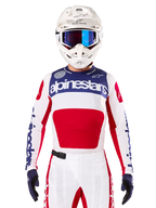 Alpinestars Limited Edition Techstar Fortitude Jersey, motorcross racing jersey, wit, rood en blauw, gedragen met bijpassende broek en helm, voorzien van Alpinestars-branding en het 'One Goal One Vision'-motto, geperforeerde details, strak ontwerp voor off-road prestaties