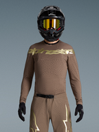 Alpinestars Supertech Air Gold jersey op model, heren motorcrossjersey, bruin en goud, met lasergesneden ventilatie.