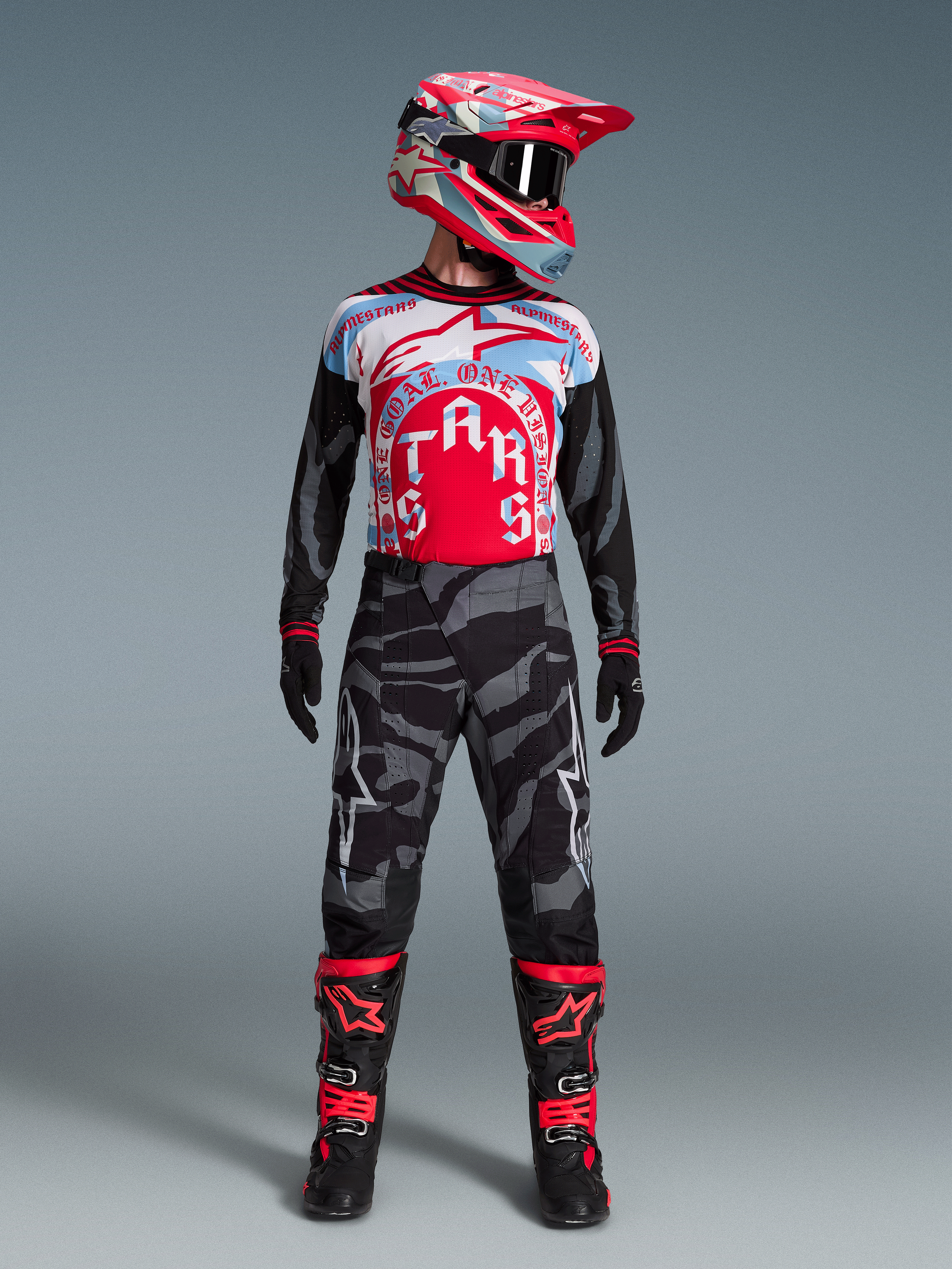 Beperkte Oplage Techstar Beast Coast motorcrossset met camouflagebroek, jersey, rode helm en zwarte laarzen.