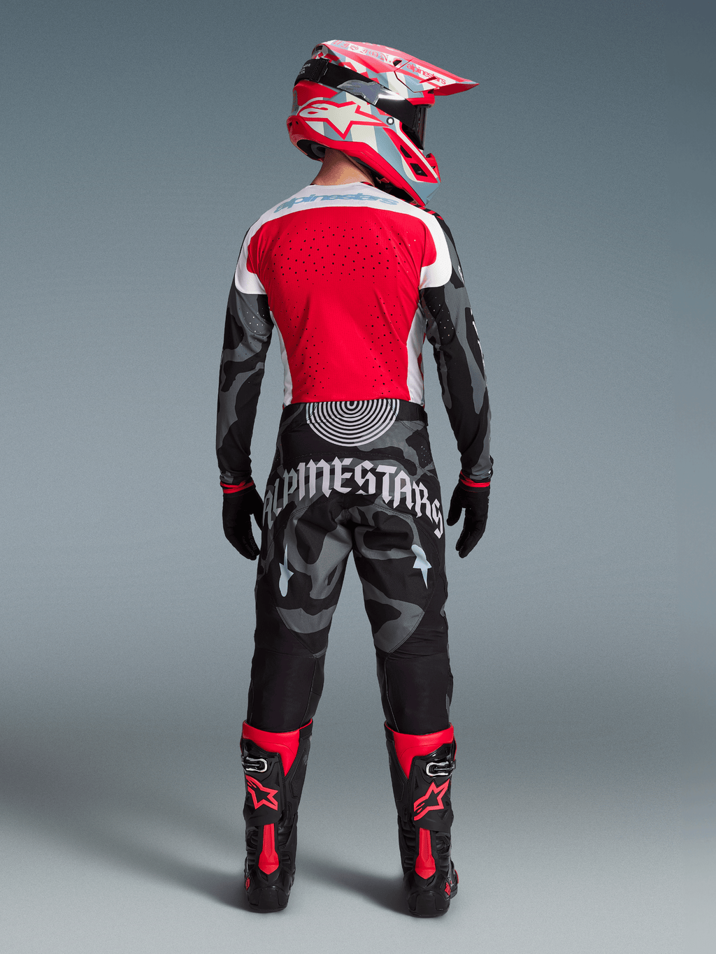 Motorcrossrijder van achteren in Beperkte Oplage Techstar Beast Coast Jersey en broek, rood met zwart camouflagedesign.