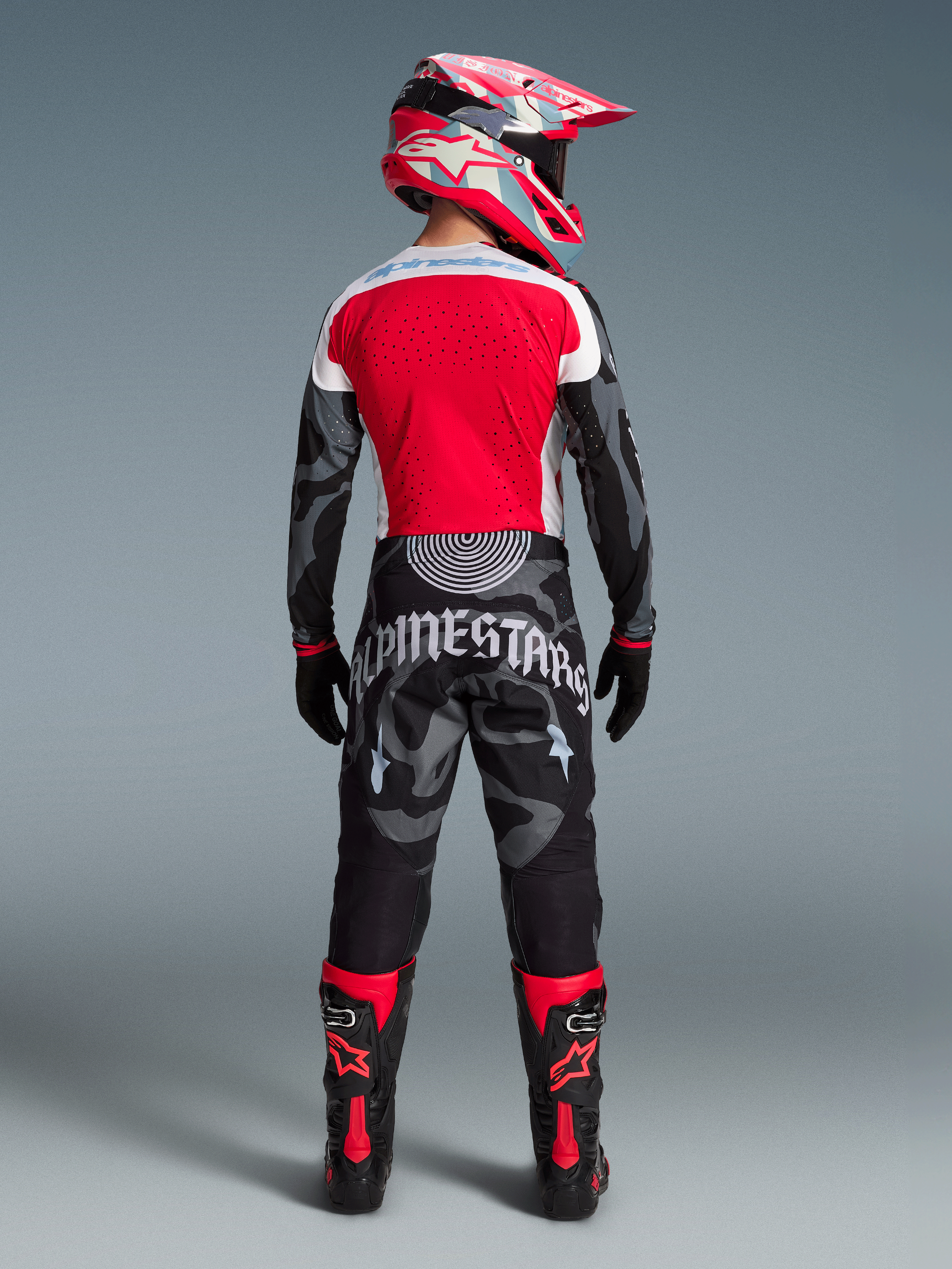 Motorcrossrijder van achteren in Beperkte Oplage Techstar Beast Coast Jersey en broek, rood met zwart camouflagedesign.