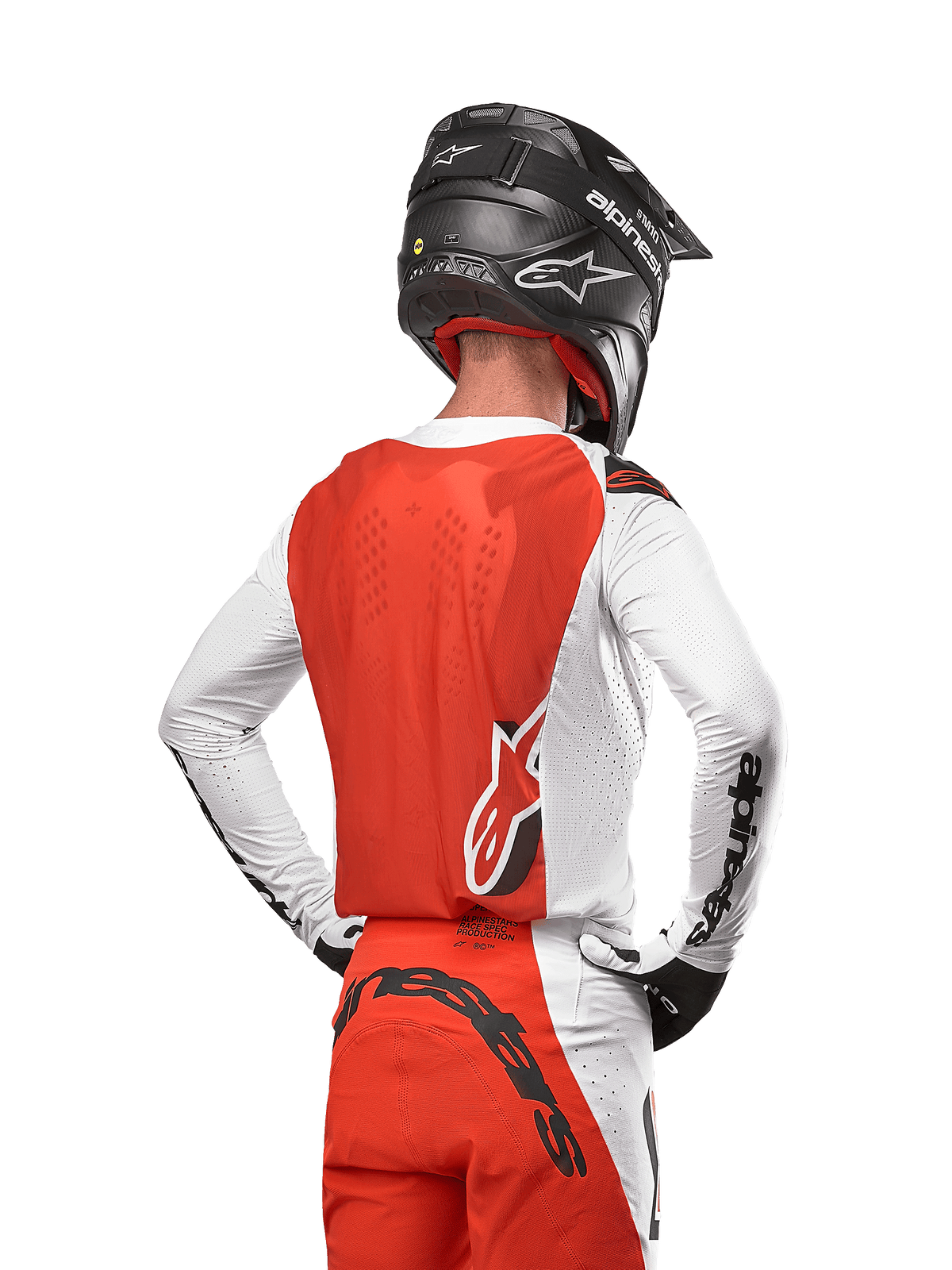 Alpinestars 2024 Supertech Ward Jersey, motorcross shirt in White Hot Orange, achteraanzicht met oranje rugpand en witte mouwen met zwart Alpinestars-logo, gecombineerd met bijpassende broek en een zwarte helm, professionele off-road race-uitrusting