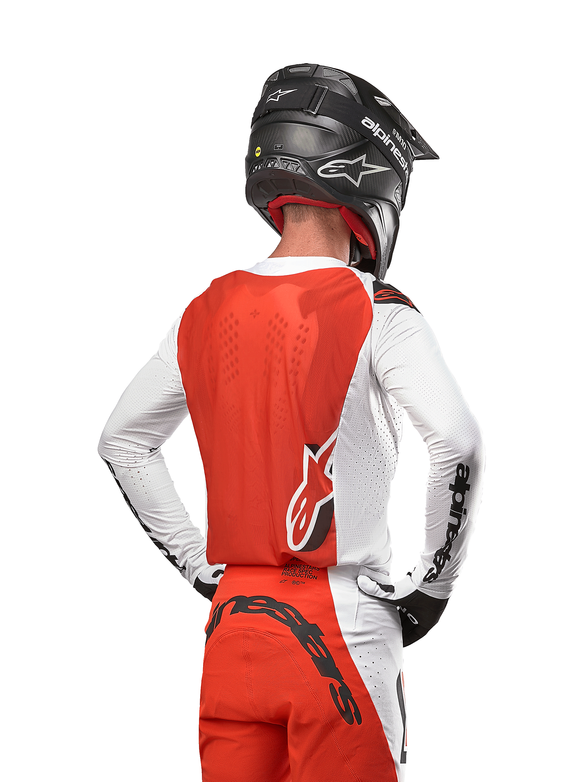 Alpinestars 2024 Supertech Ward Jersey, motorcross shirt in White Hot Orange, achteraanzicht met oranje rugpand en witte mouwen met zwart Alpinestars-logo, gecombineerd met bijpassende broek en een zwarte helm, professionele off-road race-uitrusting