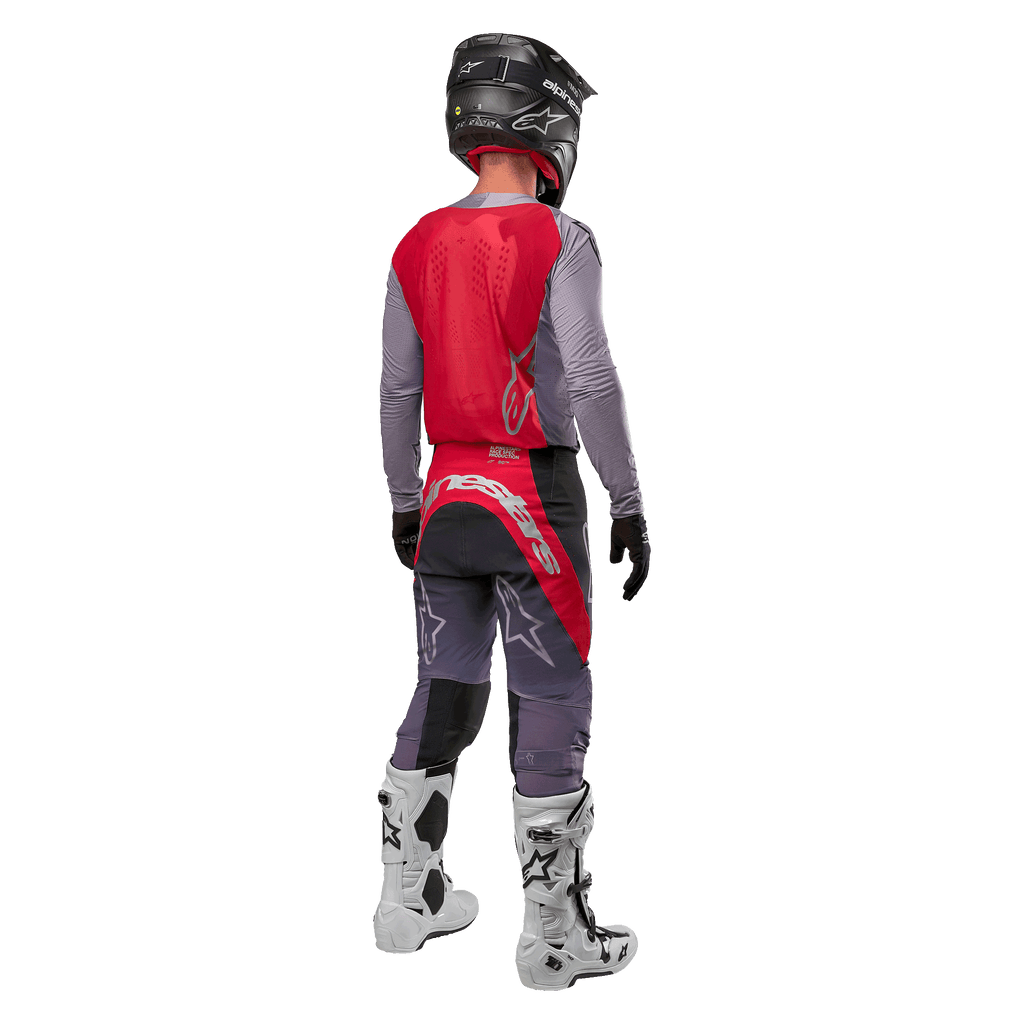 Alpinestars 2024 Supertech Dade Jersey, motocross shirt, Iron Red Berry en grijs, achteraanzicht op een rijder, voorzien van een rood rugpaneel met een grijs logo en grijze mouwen, gedragen met bijpassende grijze en rode crossbroek, witte laarzen en een zwarte helm, professionele off-road uitrusting.