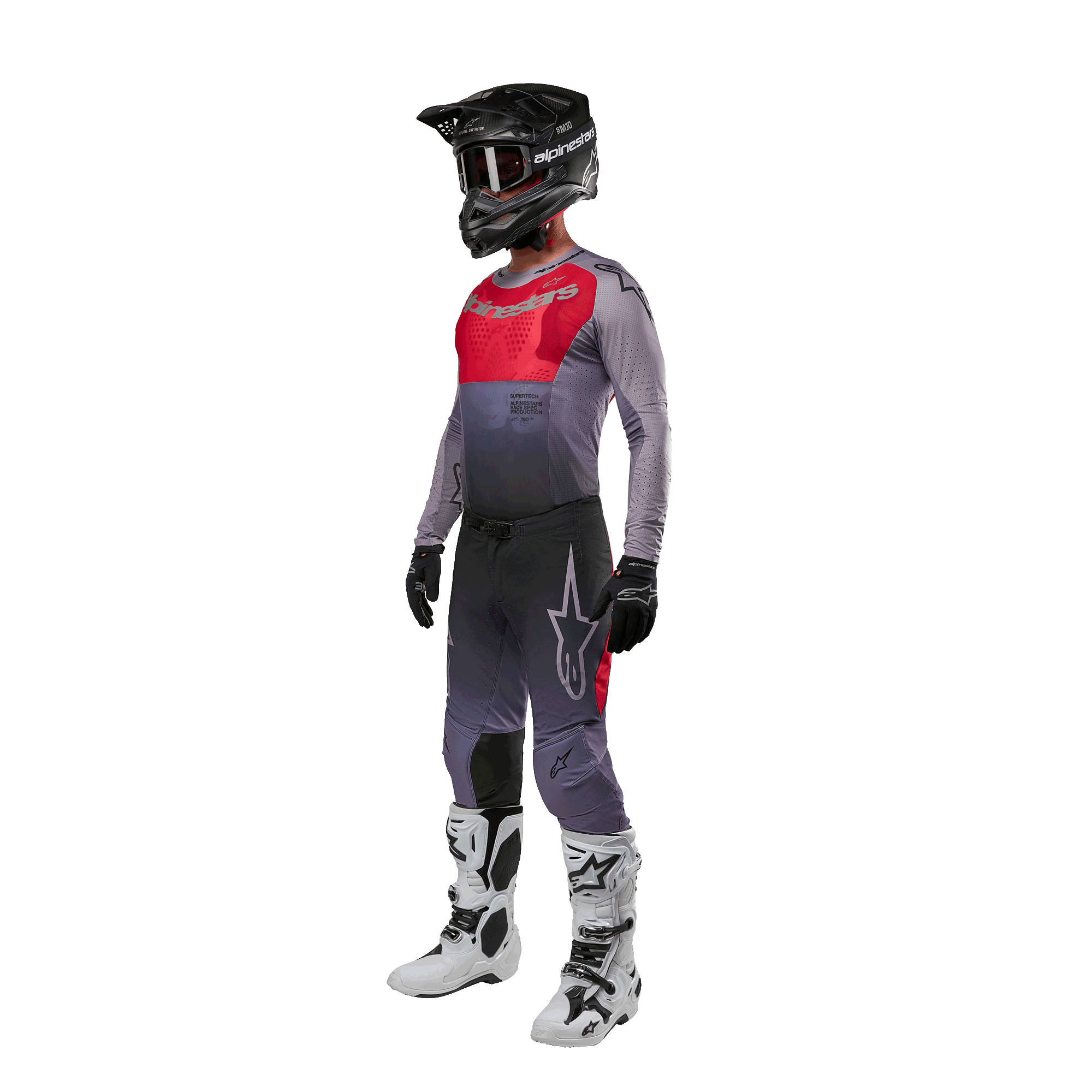 Motorcrossrijder in volledige race-uitrusting, Alpinestars 2024 Supertech Dade Jersey in Iron Red Berry en grijs, bijpassende grijze broek met rode accenten, zwarte helm met crossbril, witte en zwarte laarzen, zwarte handschoenen, gecoördineerde outfit voor off-road racen