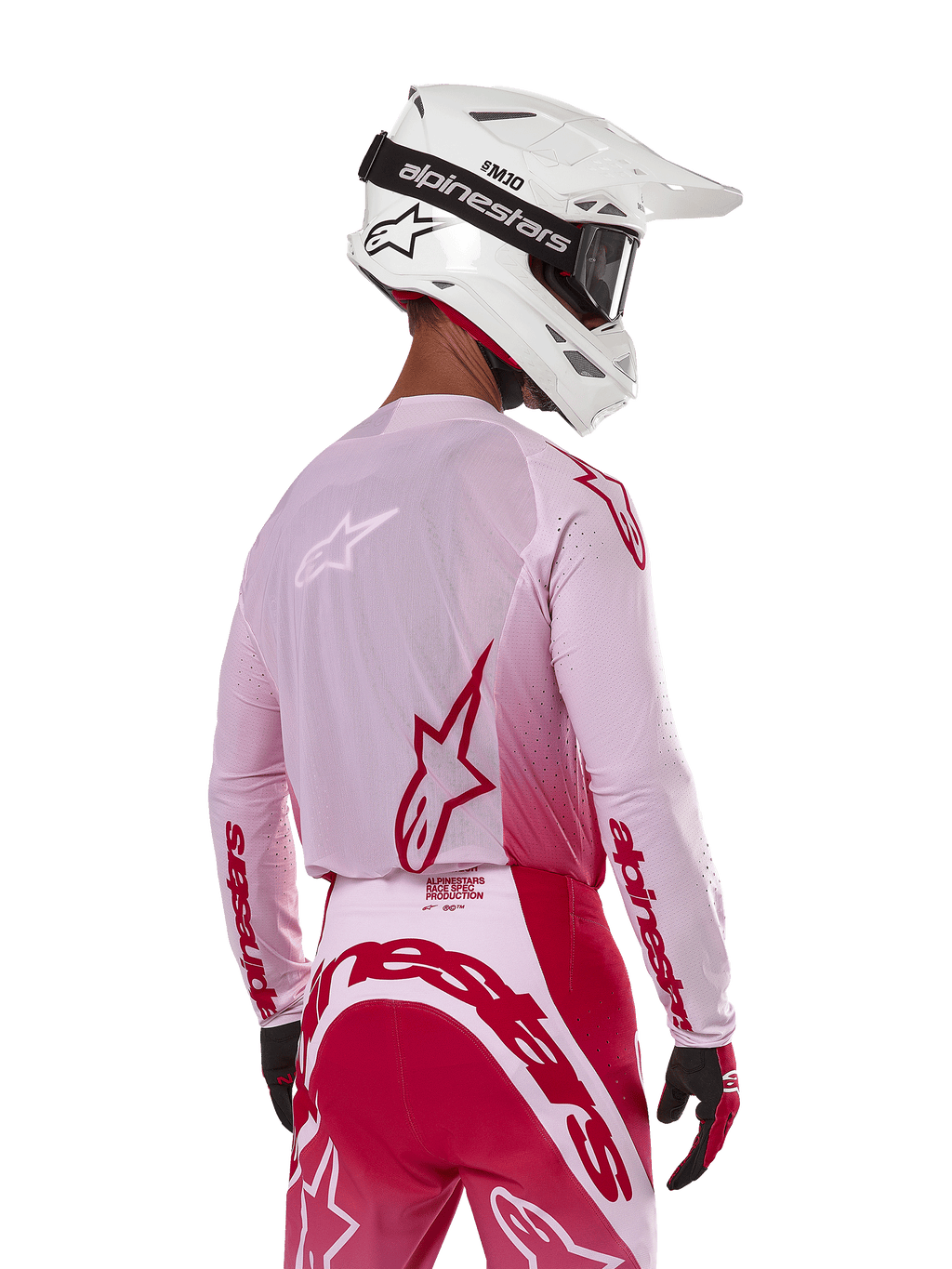 Alpinestars 2024 Supertech Dade Jersey in Red Berry Lilac, motorcrosser van achteren gezien, ademende mesh-panelen en rode Alpinestars-logo's, gecombineerd met een bijpassende rode en lila broek en een witte Alpinestars-helm met crossbril, professionele off-road race-uitrusting.