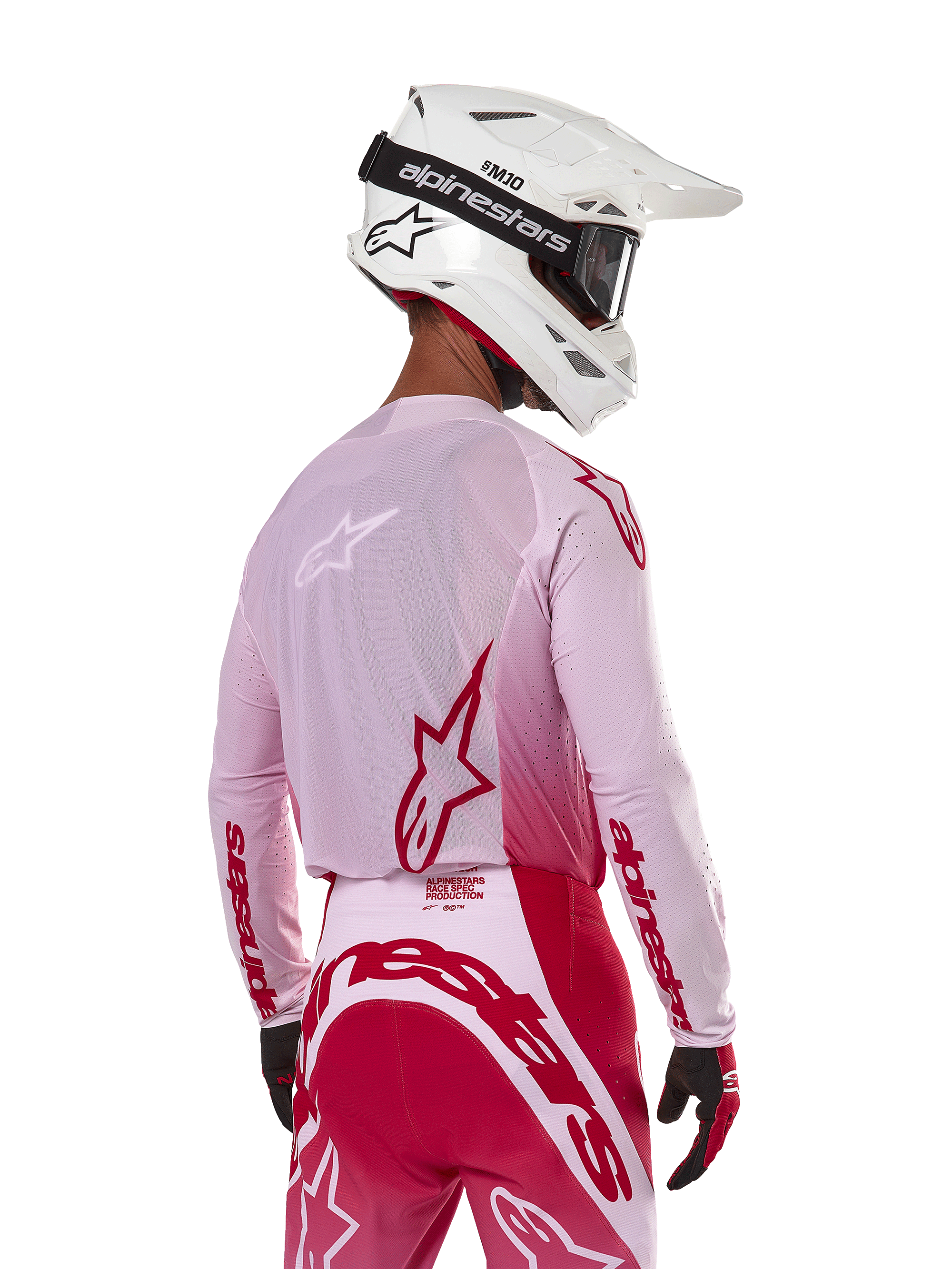 Alpinestars 2024 Supertech Dade Jersey in Red Berry Lilac, motorcrosser van achteren gezien, ademende mesh-panelen en rode Alpinestars-logo's, gecombineerd met een bijpassende rode en lila broek en een witte Alpinestars-helm met crossbril, professionele off-road race-uitrusting.
