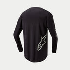 Alpinestars 2024 Fluid Graphite Jersey, motocross shirt, zwart en zilver, achteraanzicht met een zilveren sterlogo aan de onderzijde, ontwerp met lange mouwen en een verlengde achterzijde voor dekking tijdens het off-road rijden.