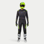 Alpinestars motorcrosser in complete race-uitrusting, 2024 Techstar Rantera Jersey in Black Navy en Yellow Fluo, bijpassende crossbroek met abstracte print, felgele fluo helm, witte en zwarte laarzen, gecoördineerde outfit voor off-road racing