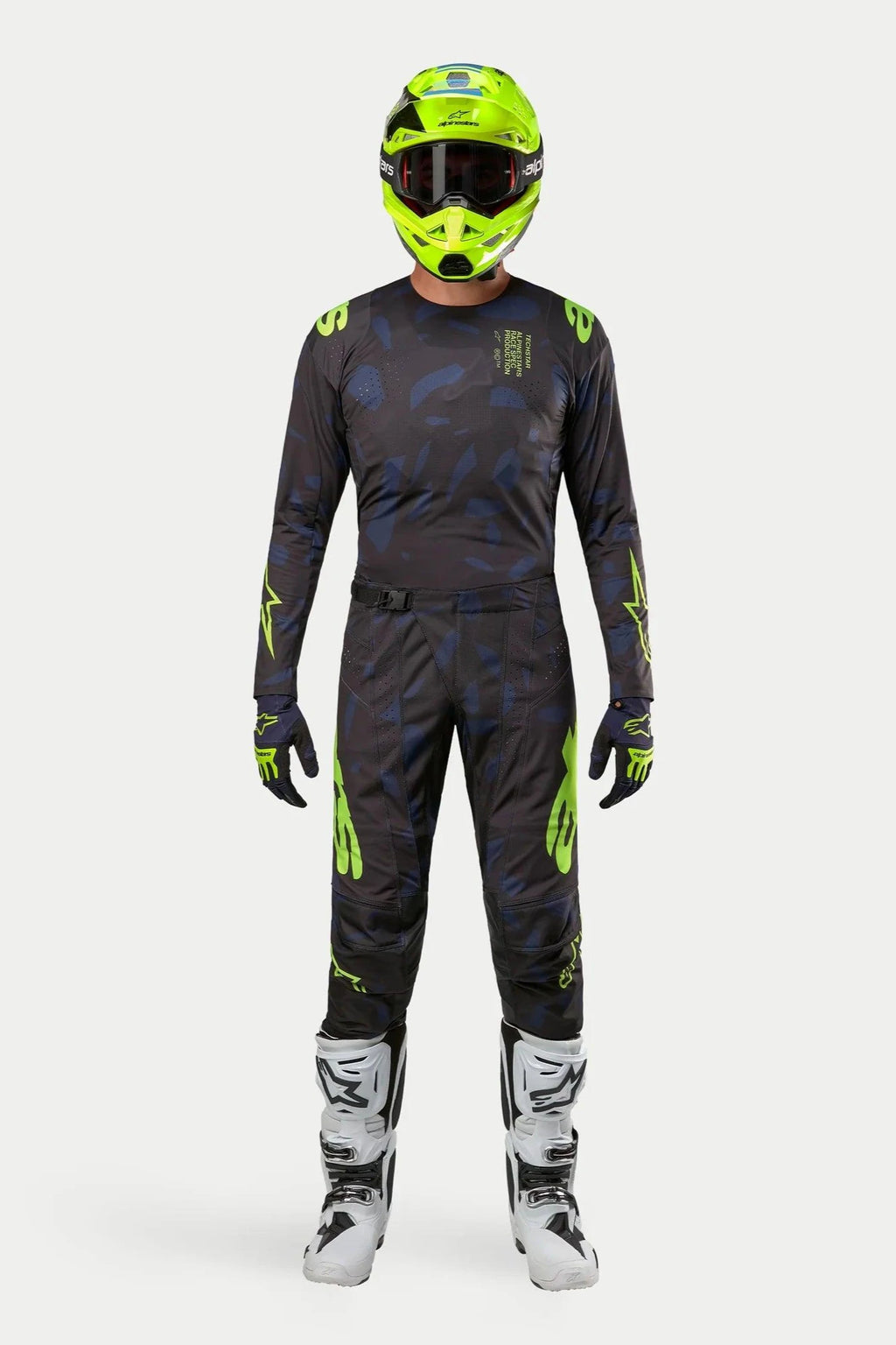 Alpinestars 2024 Techstar Rantera Jersey en broek, motorcross kledingset, zwart, navy en fluogeel, gedragen met een bijpassende fluogele helm en witte laarzen, voorzien van opvallende gele logo's en technische mesh-panelen voor off-road prestaties