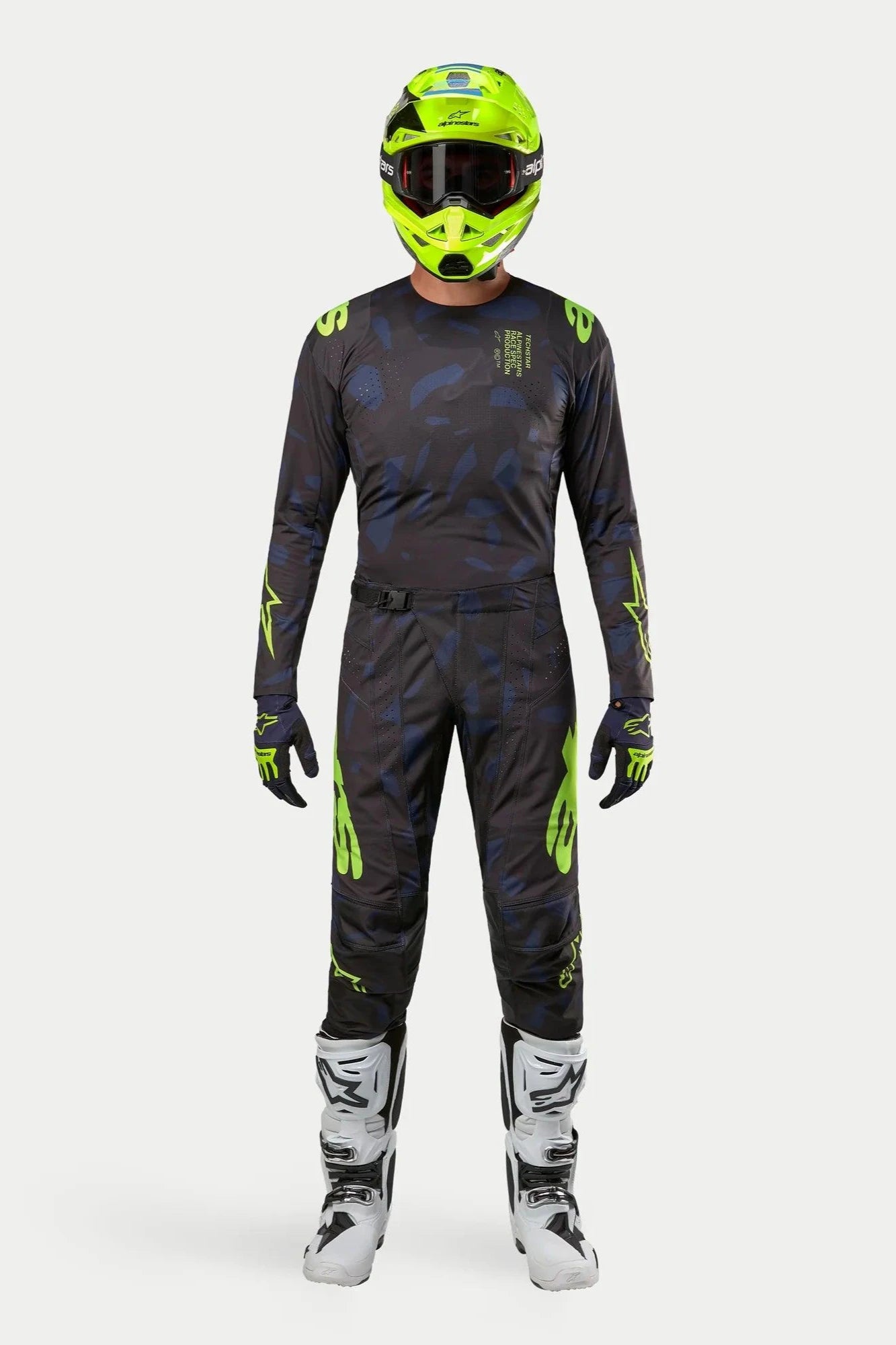 Alpinestars 2024 Techstar Rantera Jersey en broek, motorcross kledingset, zwart, navy en fluogeel, gedragen met een bijpassende fluogele helm en witte laarzen, voorzien van opvallende gele logo's en technische mesh-panelen voor off-road prestaties