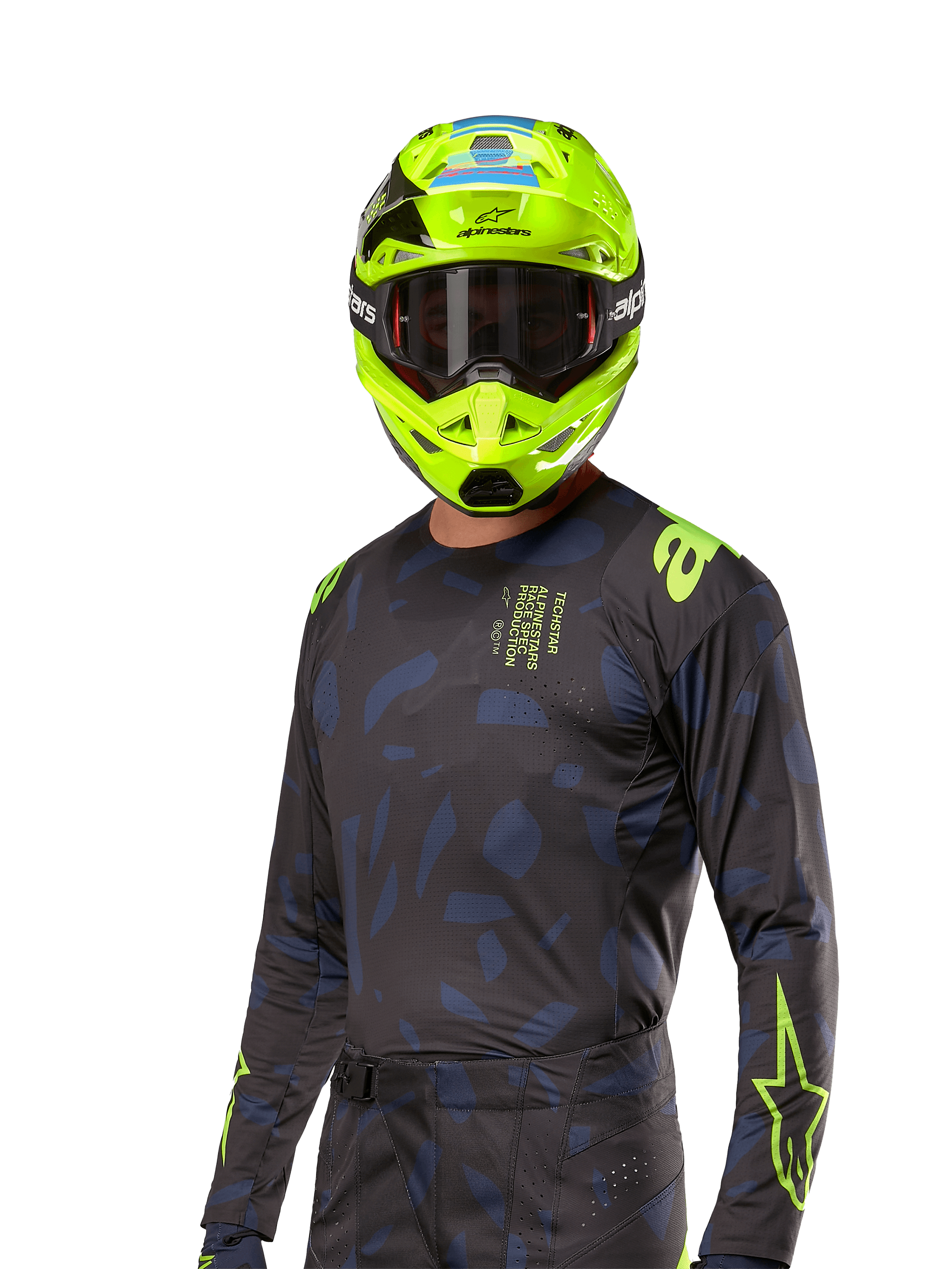 Alpinestars 2024 Techstar Rantera jersey, motorcross raceshirt, zwart en navy met abstracte patronen en neongele accenten, gedragen met bijpassende neongele helm, sportieve pasvorm voor off-road rijden