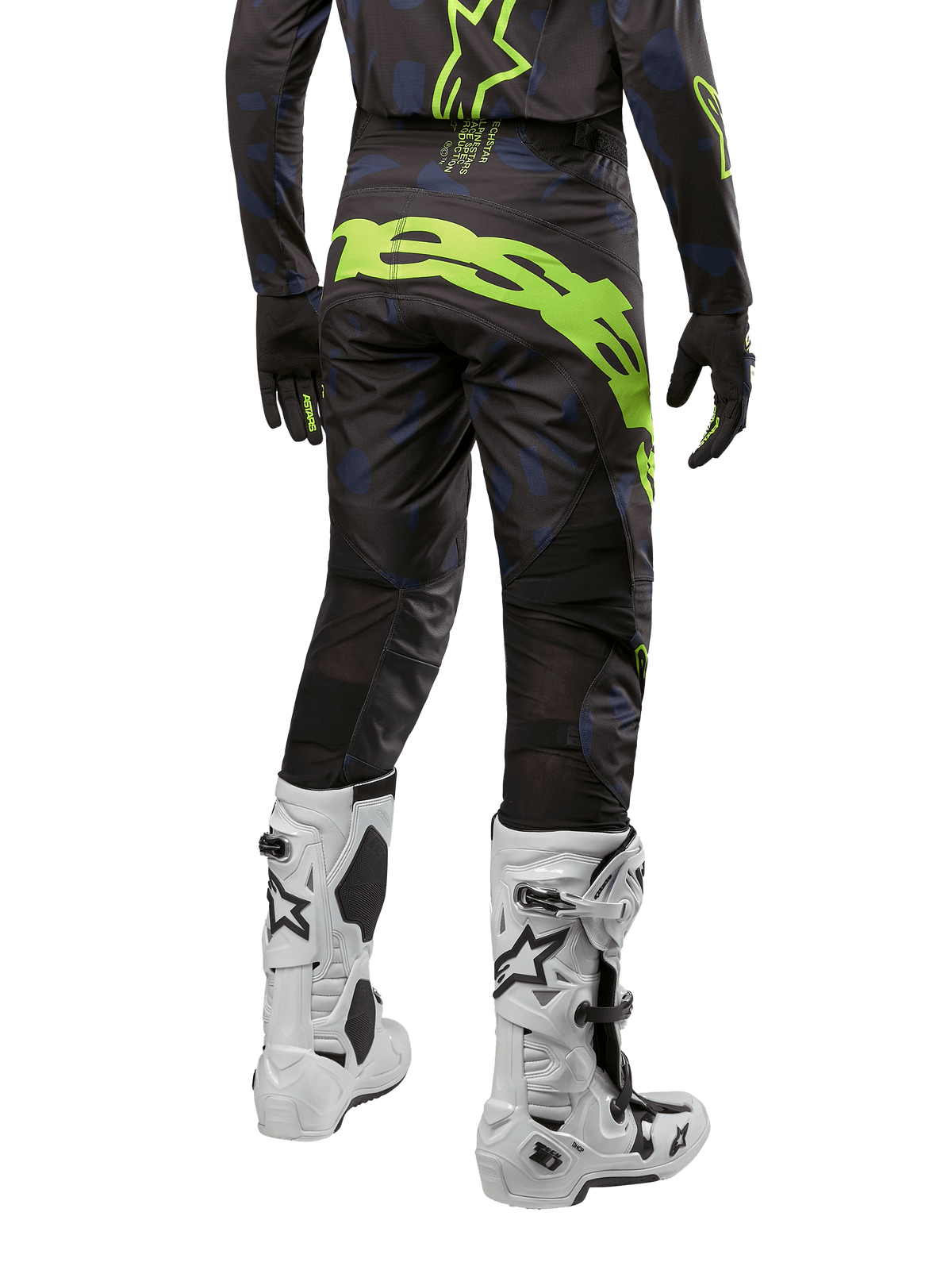 Alpinestars 2024 Techstar Rantera broek, motorcross broek, zwart, navy blauw en fluo geel, achteraanzicht, met opvallende neongele branding en mesh ventilatiepanelen, gedragen met bijpassende jersey en witte laarzen, duurzame uitrusting voor motorcross en off-road racing