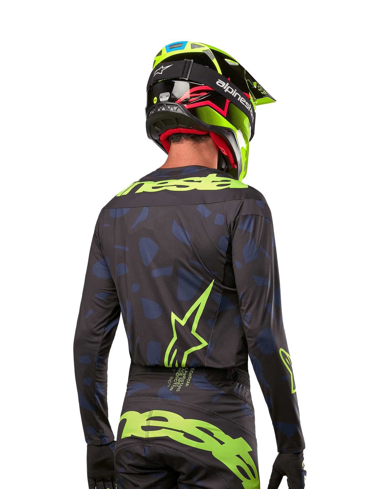 Achteraanzicht van een motorcrossrijder die het Alpinestars 2024 Techstar Rantera Jersey draagt in Black Navy Yellow Fluo, met opvallende fluo-gele branding en logo's op de rug, gecombineerd met een bijpassende motorcrossbroek en een neongele helm voor een complete off-road racing-look.