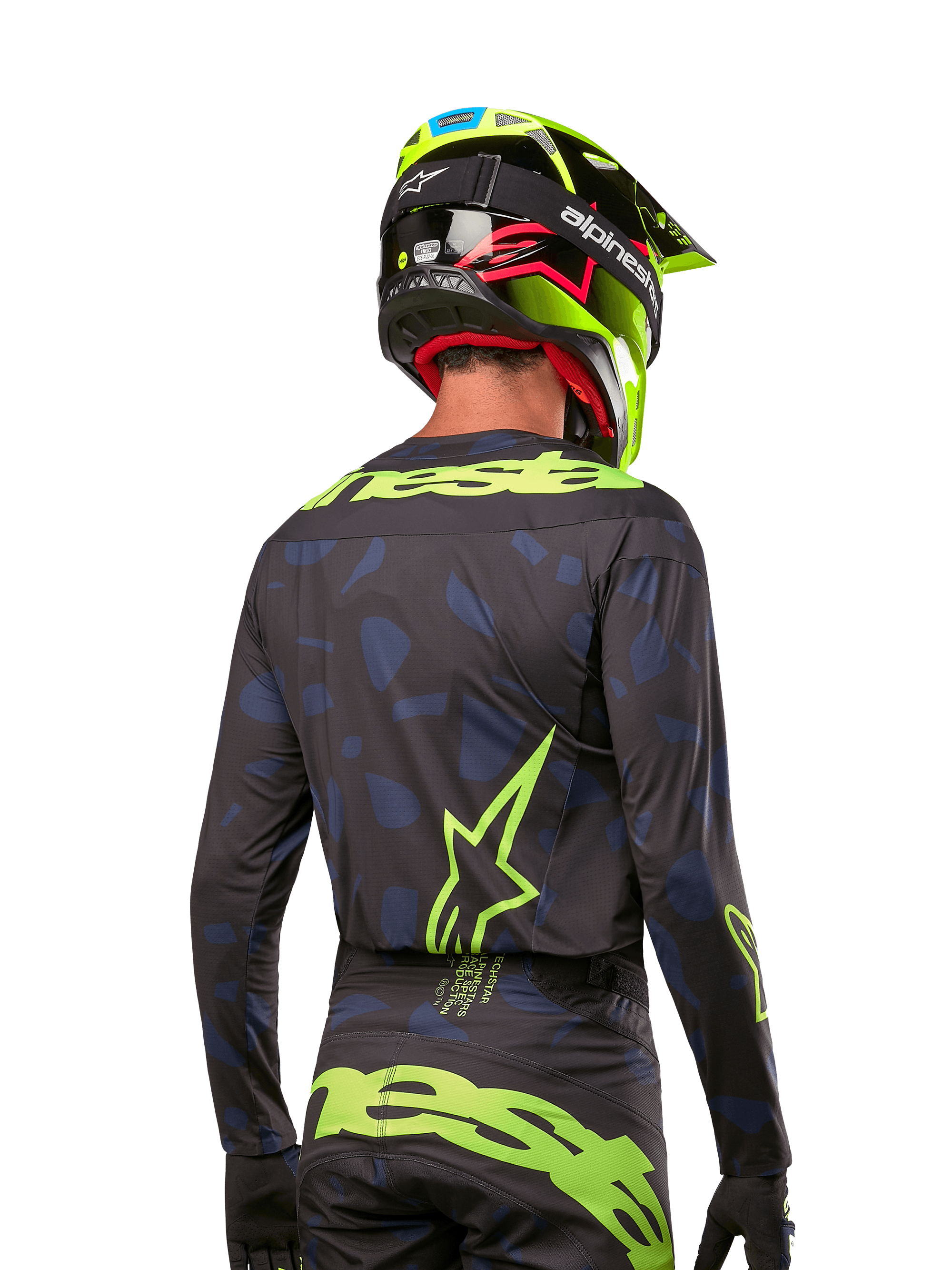 Achteraanzicht van een motorcrossrijder die het Alpinestars 2024 Techstar Rantera Jersey draagt in Black Navy Yellow Fluo, met opvallende fluo-gele branding en logo's op de rug, gecombineerd met een bijpassende motorcrossbroek en een neongele helm voor een complete off-road racing-look.