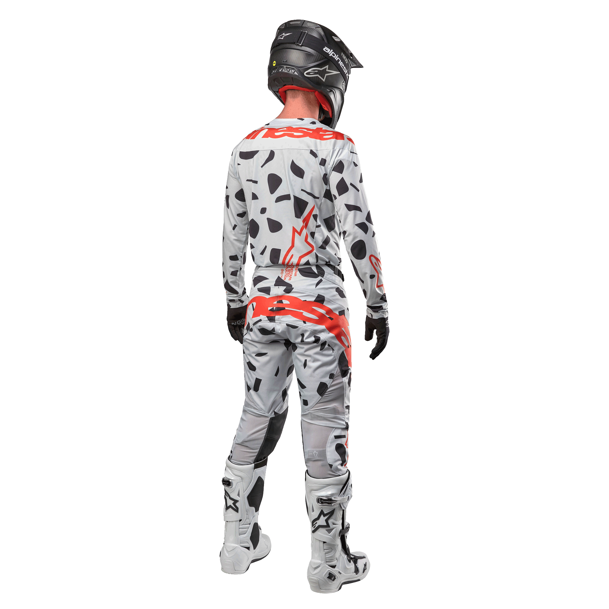 Motocrosser van achteren in Alpinestars 2024 Techstar Rantera Jersey en bijpassende broek, Haze Gray Camo-patroon met opvallende rode Alpinestars-logo's, zwarte helm, witte en zwarte laarzen, zwarte handschoenen, gecoördineerde motorcross-set.