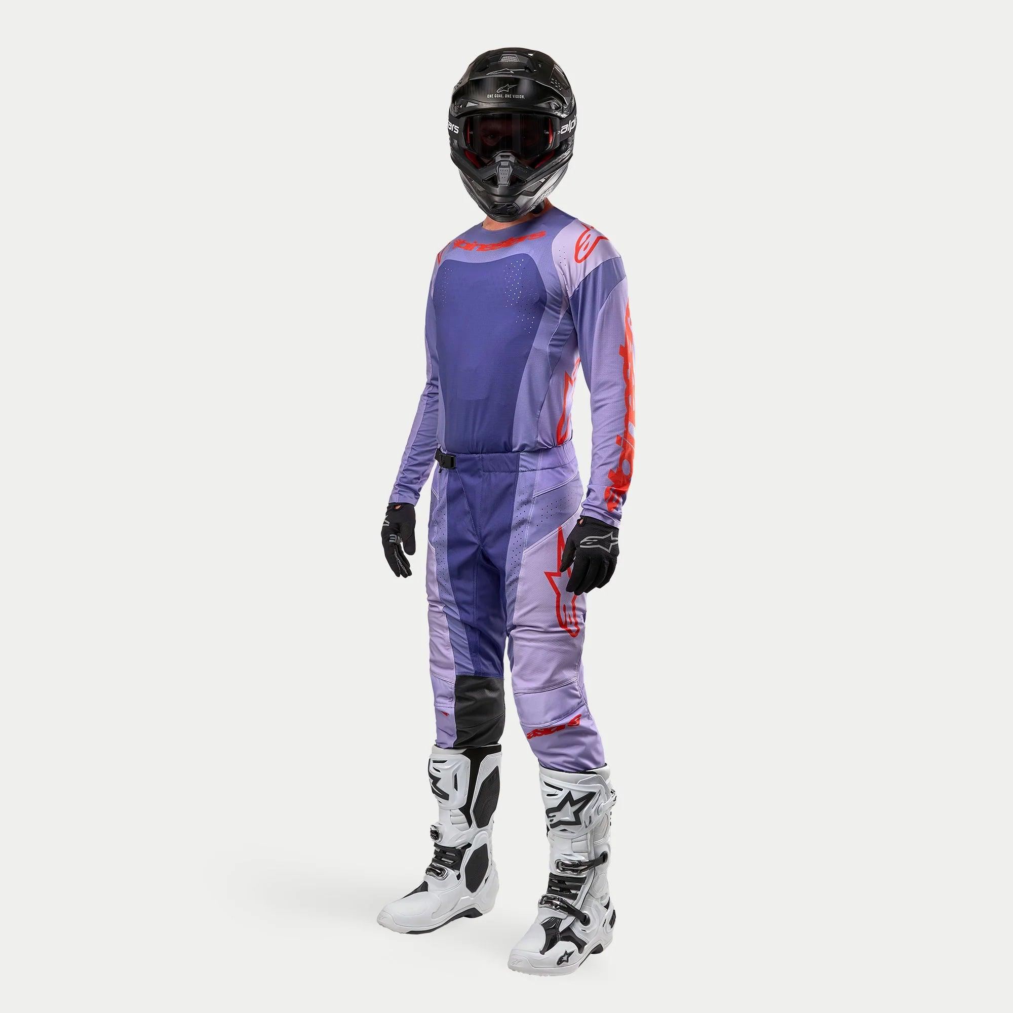 Alpinestars 2024 Techstar Ocuri motorcross outfit, paars en feloranje tenue, jersey en broek met witte crosslaarzen en zwarte helm, professionele uitrusting voor off-road rijden
