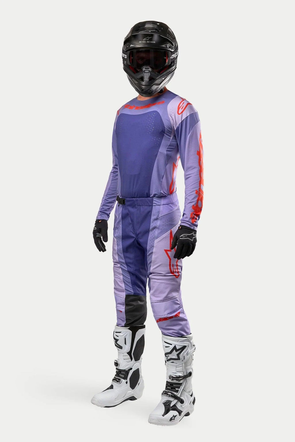 Motocross-rijder in de Alpinestars 2024 Techstar Ocuri Jersey in Purple Hot Orange, bijpassende paarse motorcrossbroek met oranje accenten, zwarte helm, witte en zwarte laarzen en zwarte handschoenen, volledige off-road wedstrijduitrusting