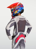 Alpinestars jeugd Supertech Swan jersey 2027, ademende motorcrossjersey in grijs en lila, achteraanzicht op de rijder.