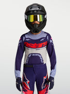 Alpinestars jeugd Supertech Dyna jersey, paars en grijs motocross jersey met atletische racepasvorm, gedragen door jonge rijder.