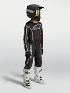 Alpinestars Jeugd Fluid Apex V2 jersey en uitrustingsset, zwart en zilver, motocrossoutfit gedragen door een jong model.