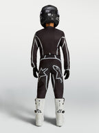 Alpinestars Jeugd Fluid Apex V2 jersey en motocrossuitrusting, zwart en zilver, achteraanzicht met witte motorlaarzen.