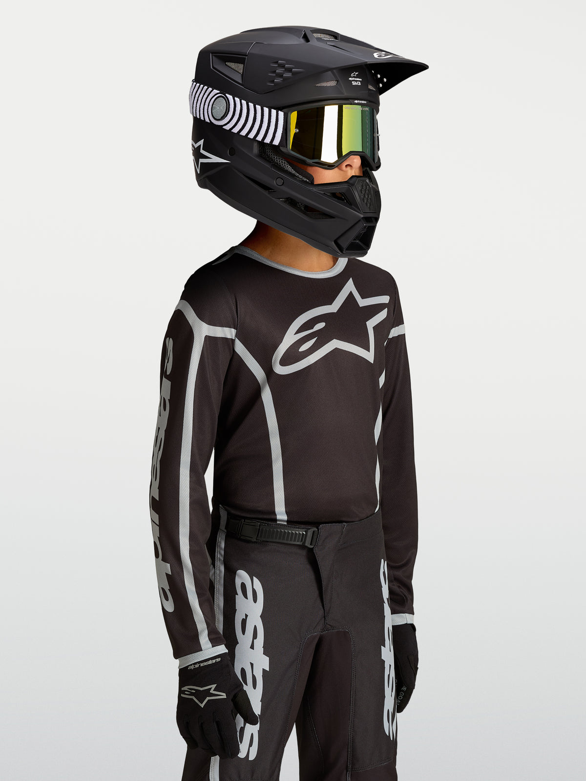 Alpinestars Jeugd Fluid Apex V2 jersey, zwart en zilver, vochtafvoerend polyfabric met logo voor jonge motorcrossers.