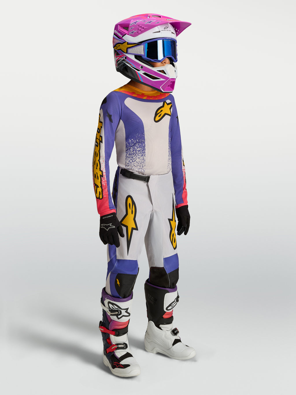 Alpinestars jeugd Fluid Drag gearset en jersey, motorcrossuitrusting, blauw en wit met roze en gouden accenten.