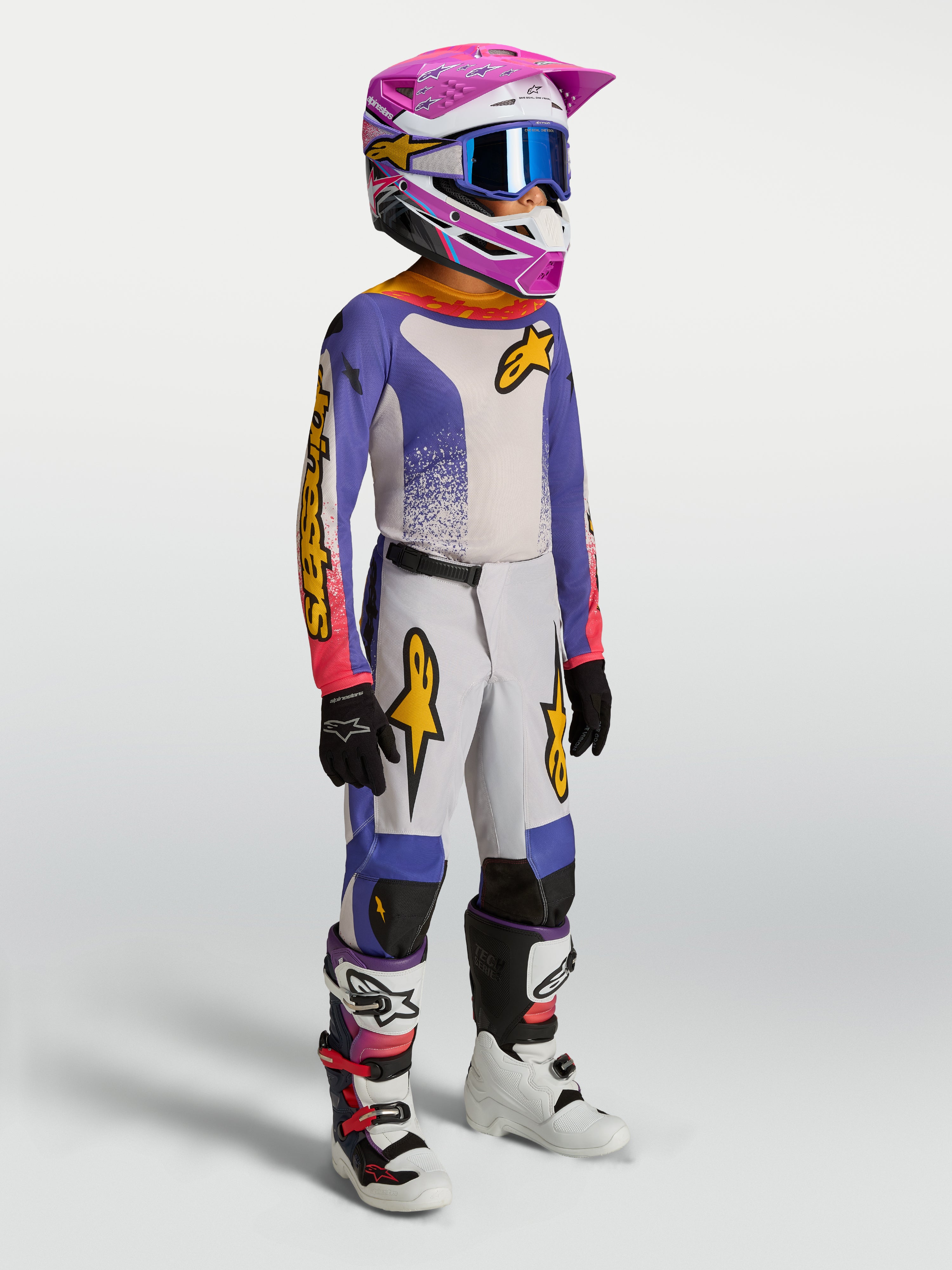 Alpinestars jeugd Fluid Drag gearset en jersey, motorcrossuitrusting, blauw en wit met roze en gouden accenten.